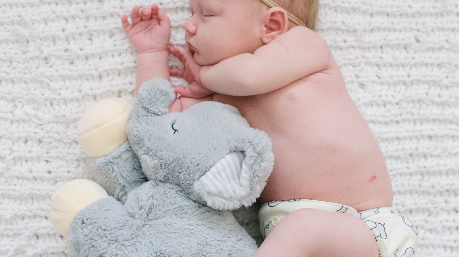 newborn baby with a toy elephant